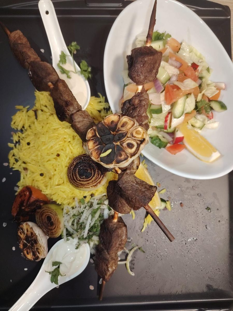 Charcoal lamb skewers with turmeric rice, blackened garlic, grilled onion and a side salad